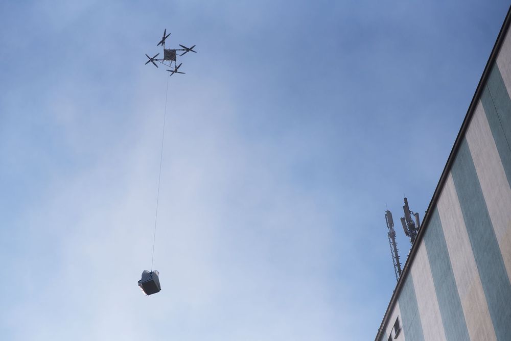 Il multicottero FB3 sta sollevando l'attrezzatura per il montaggio dell'antenna.